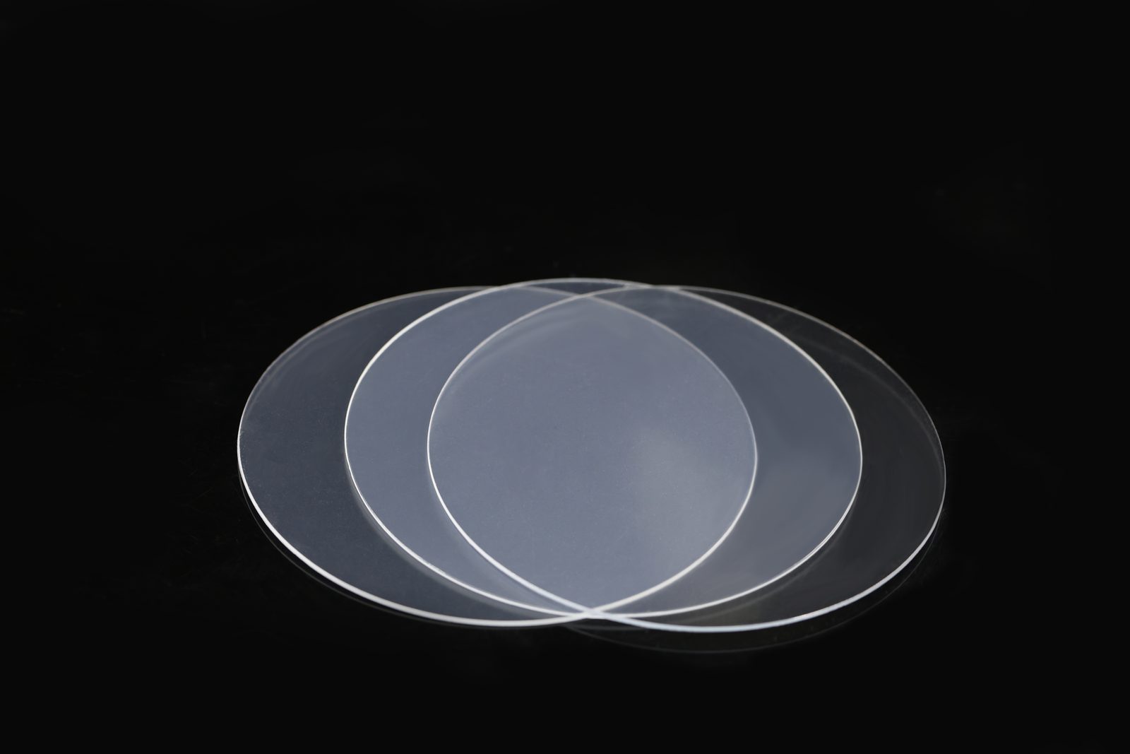 Three Maxflex clear thermoforming sheets fanned out on a black background